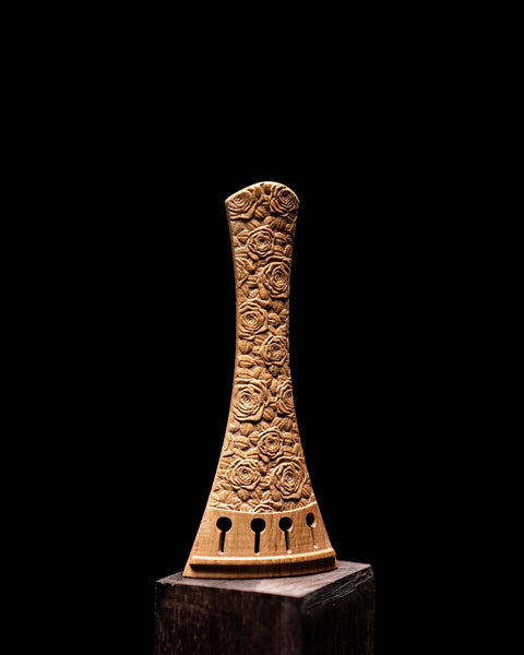 A “Rose” violin tailpiece, depicted here carved in Southern Live Oak wood